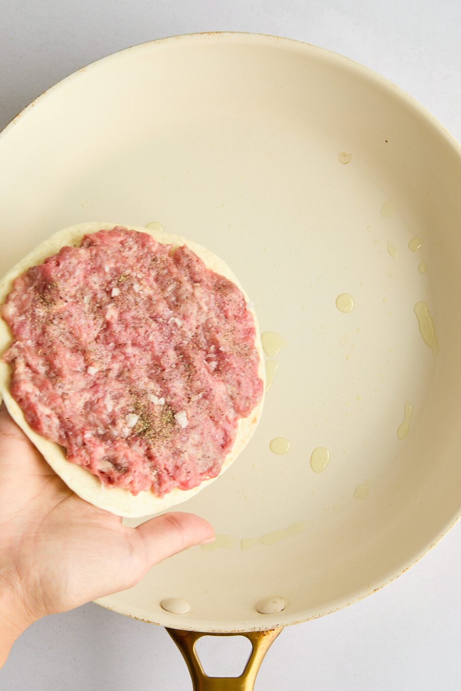 a photo of the meat pressed on the tortilla. 