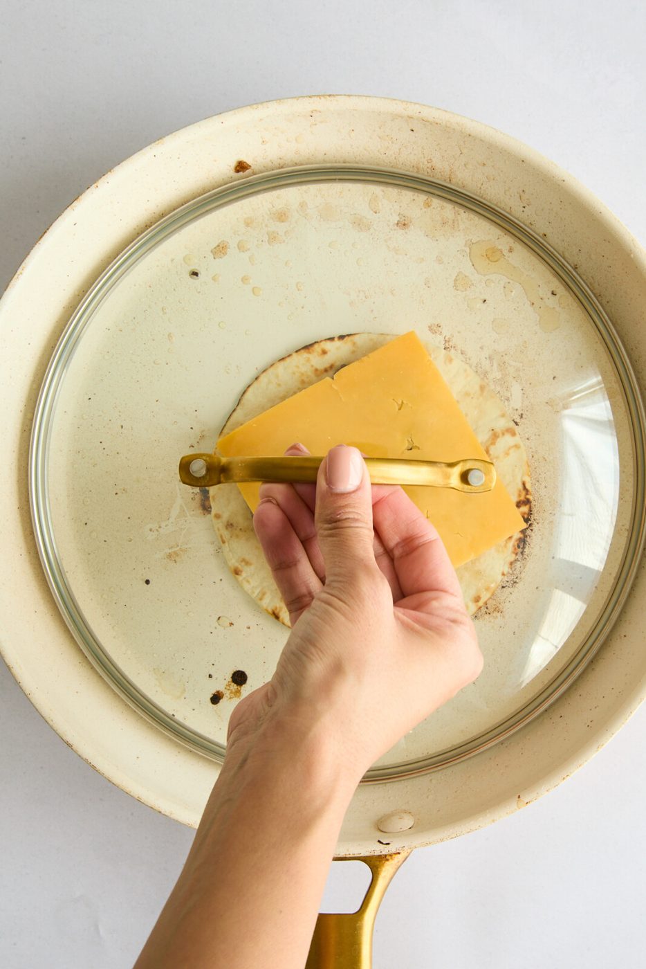 Cheese on top of the meat with a lid on top. Last step of the Big Mac smash taco. 
