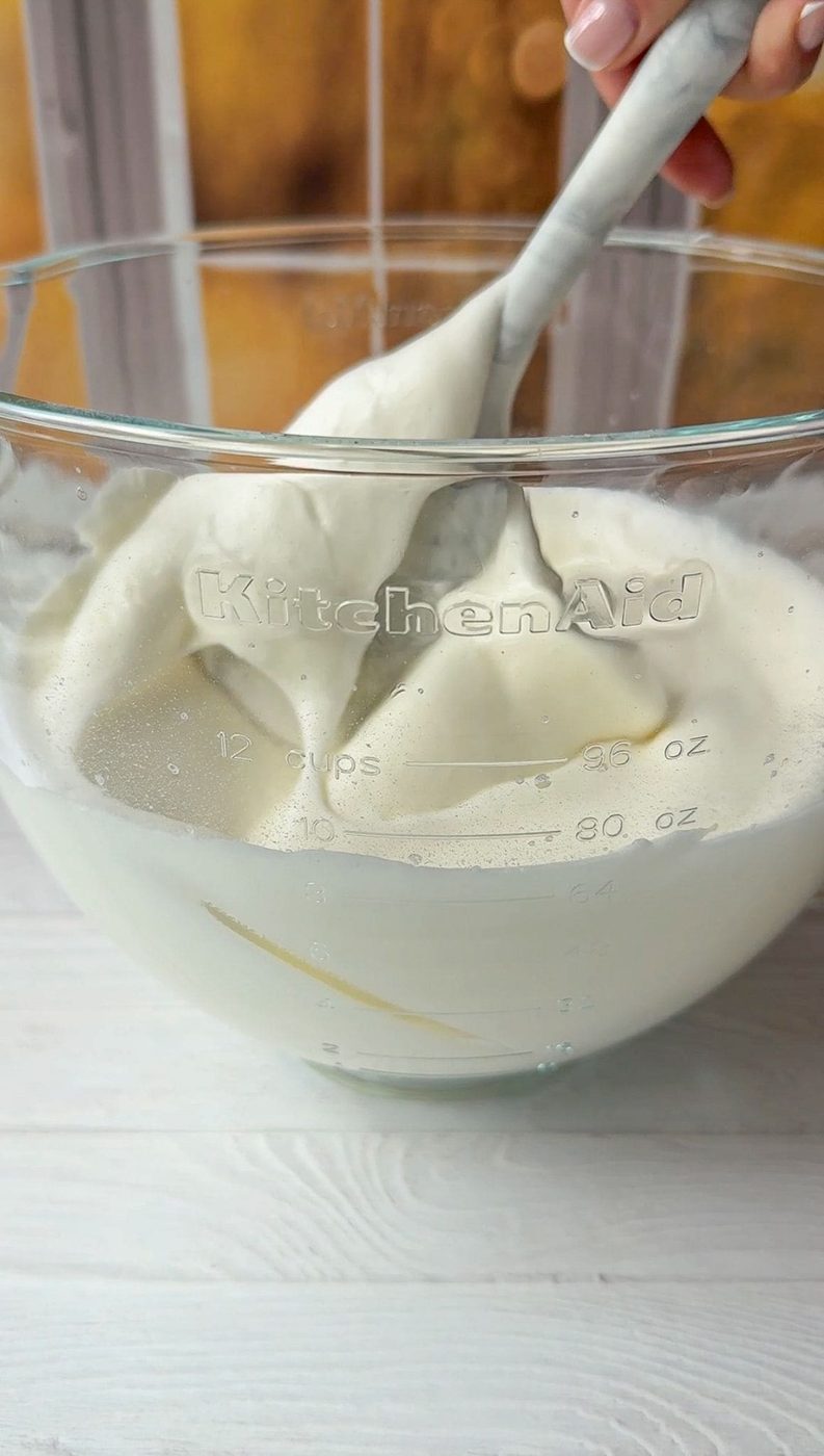 The yogurt is being gently folded into the fluffy egg whites.