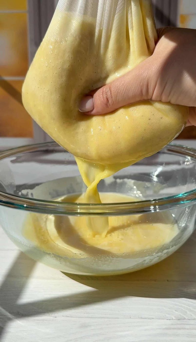 Squeezing the nut milk bag with the juice over a bowl to catch the pulp