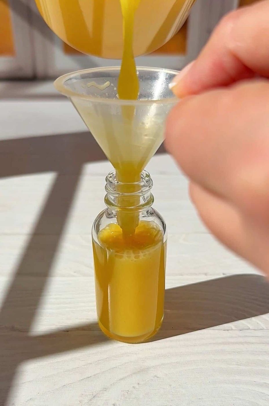 pouring the juice into our ginger shot bottles with a small funnel. You have now made your ginger shots.
