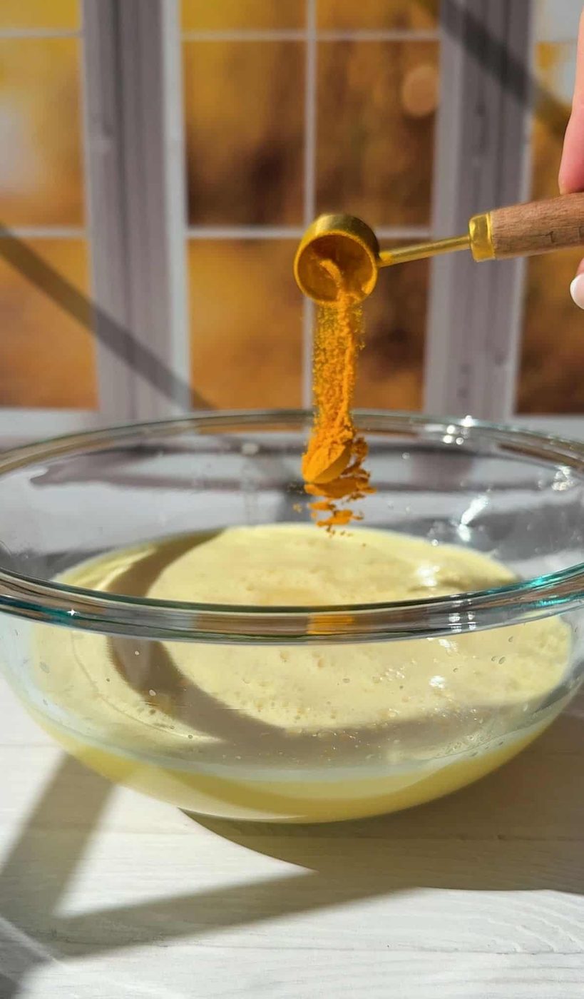 adding organic ground turmeric to the strained juice and mixing it