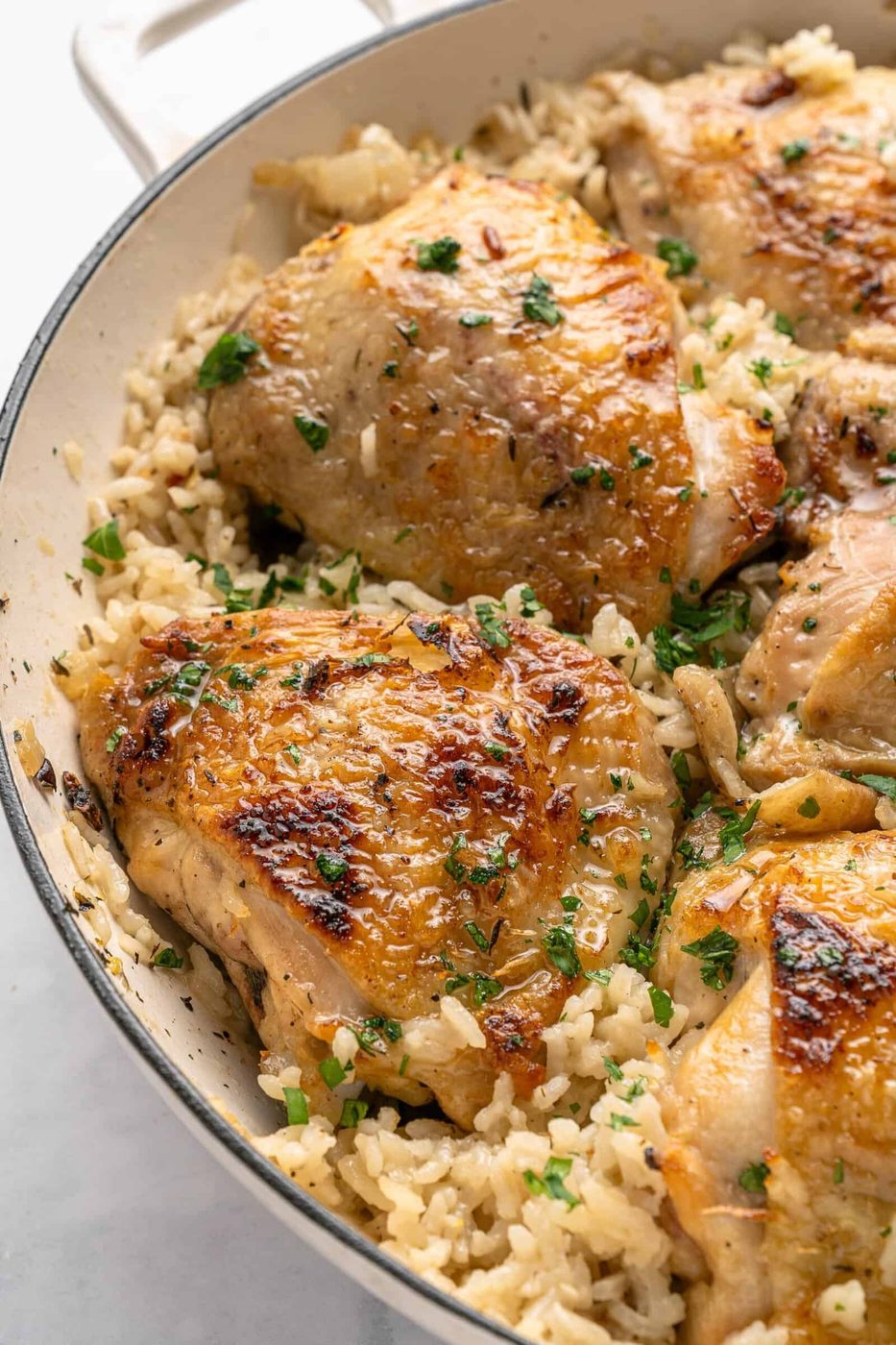 Image of a cooked one pan chicken dinner with rice and parsley on top. 