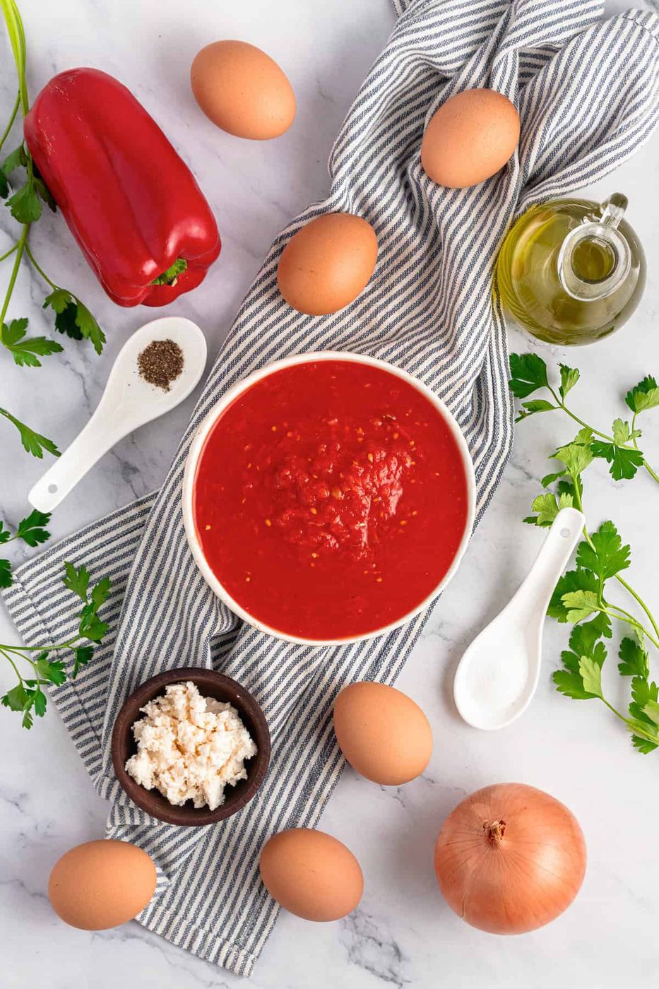 These are all of the ingredients for the Shakshouka. Eggs, feta, tomatoes, peppers, onions, parsley, salt.