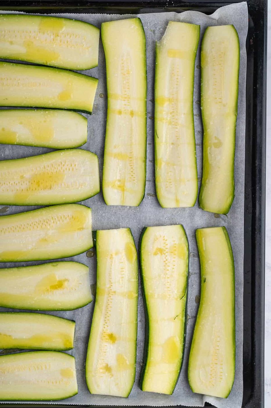 Picture of the zucchini on a baking sheet drizzled with olive oil 