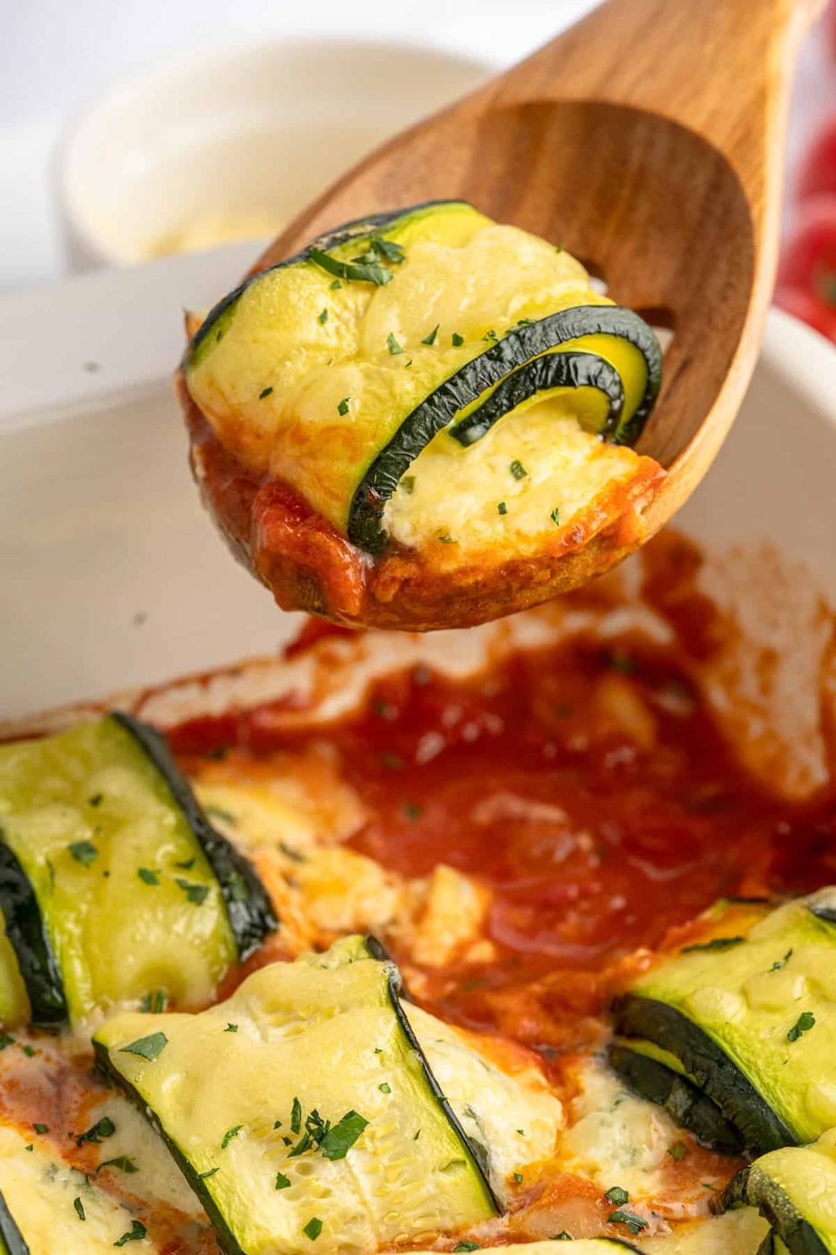 Baking dish full of zucchini lasagna rolls. 