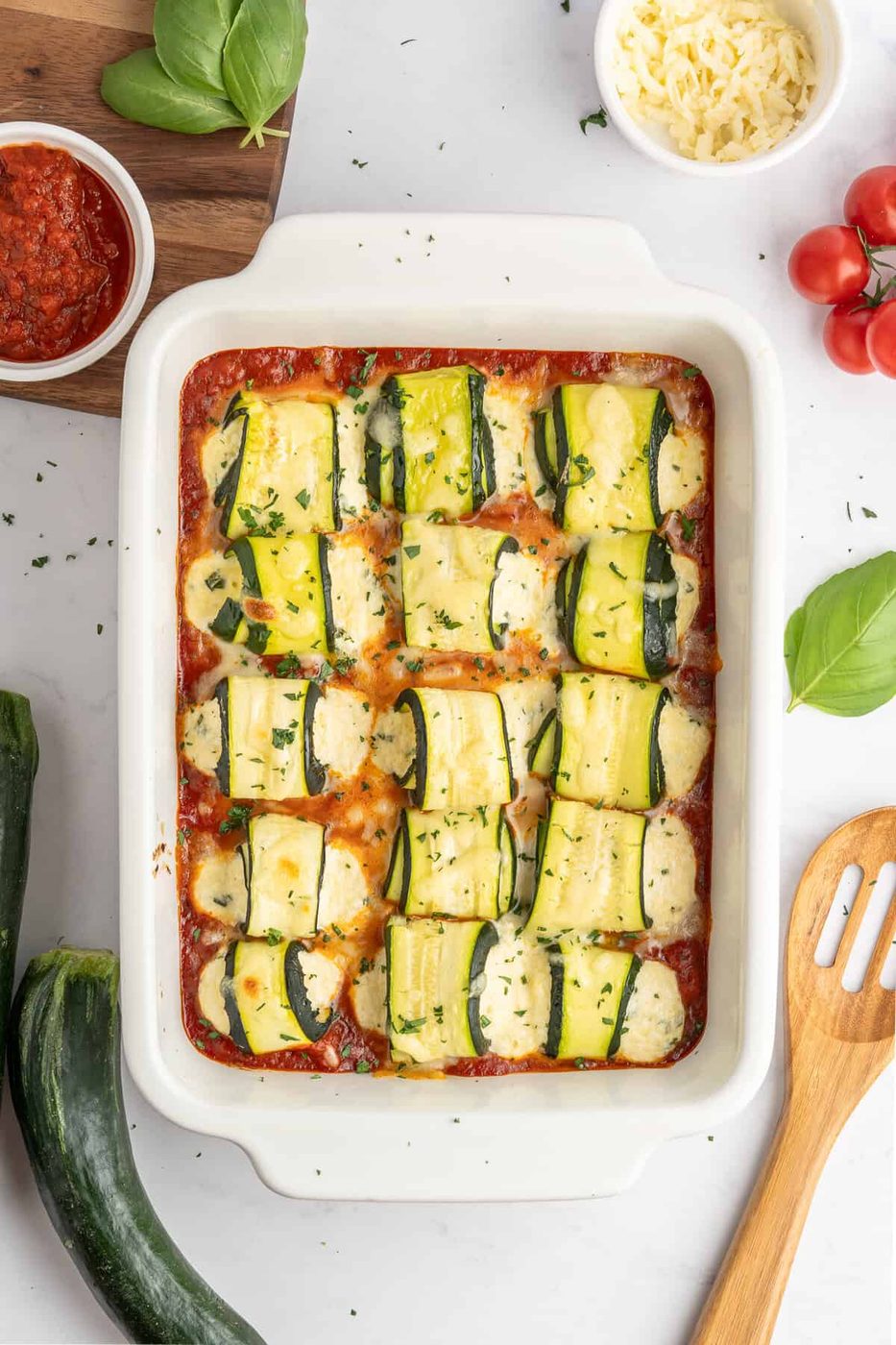 a tray full of baked zucchini lasagna rolls 