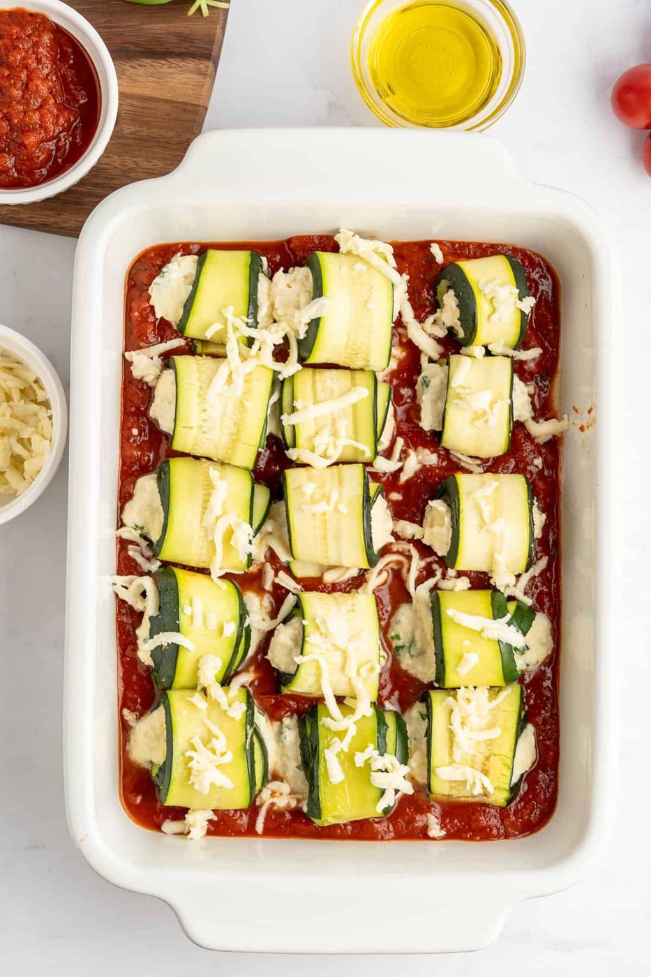 tray ready to go in the oven of the unbaked zucchini lasagna rolls