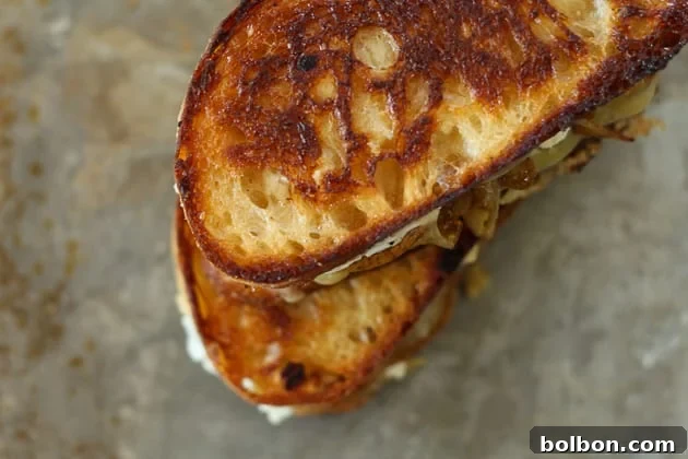 The golden-brown perfection of a grilled cheese sandwich, signifying a crispy exterior and molten interior.