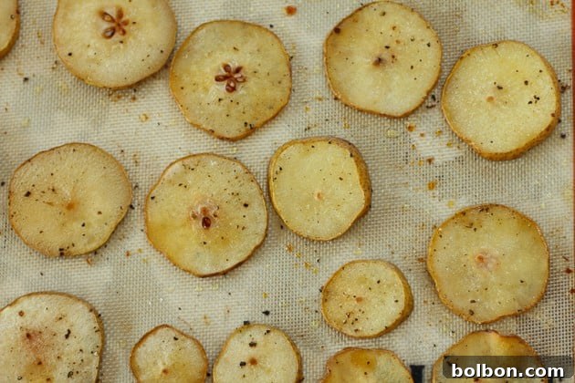 Sliced pears lightly brushed with olive oil and seasoned, ready for roasting to achieve tender sweetness.