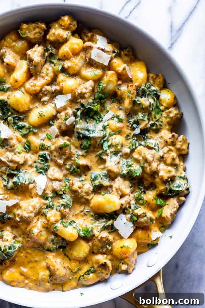 Sautéing ingredients for a quick and easy pumpkin gnocchi sauce. A skillet filled with creamy pumpkin sausage gnocchi, simmering to perfection.