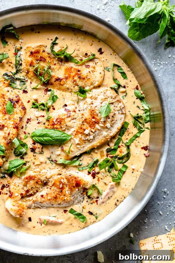 Creamy Parmesan Basil Chicken served in a skillet, garnished with fresh basil