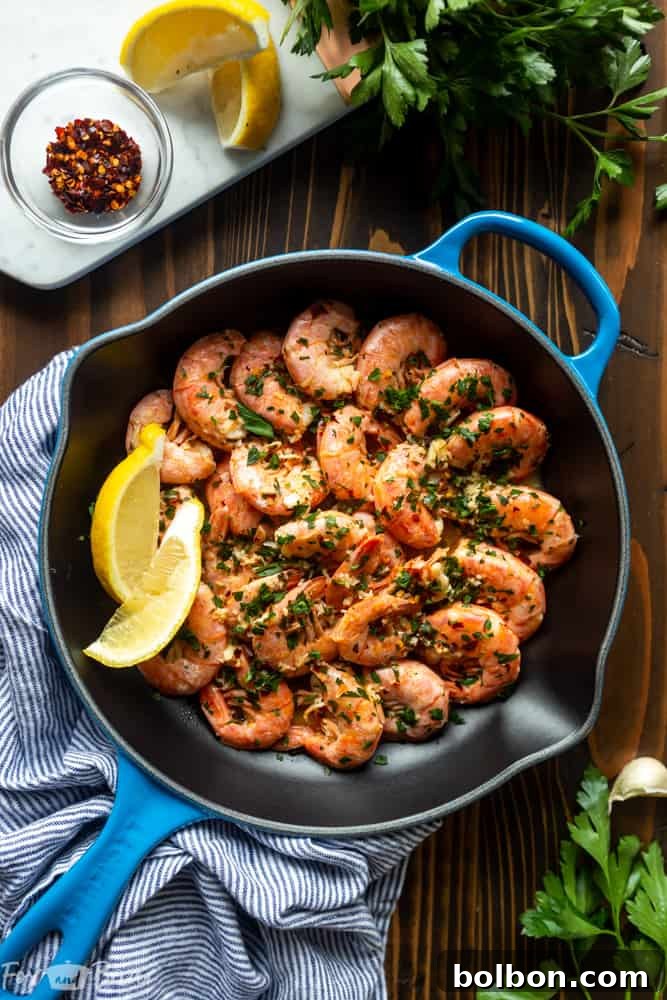 Plate of Easy Garlic Butter Shrimp garnished with fresh parsley and lemon wedges