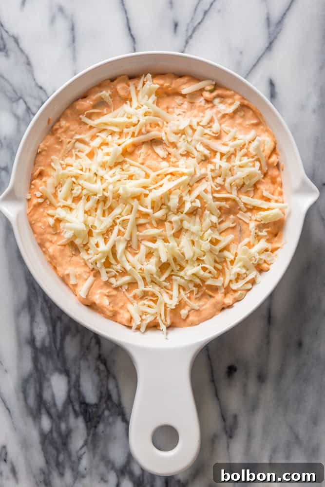 Buffalo Chicken Dip before baking Unbaked buffalo chicken dip in a baking dish, ready for the oven