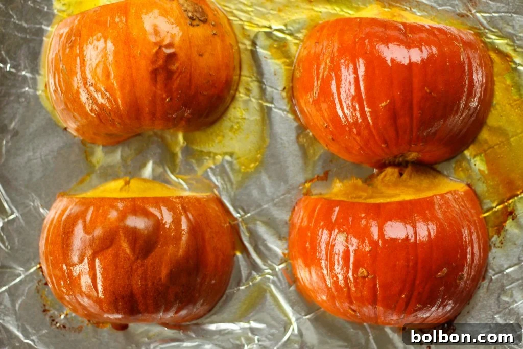 A close-up shot of a perfectly roasted pumpkin half, with tender, vibrant orange flesh ready for the soup.