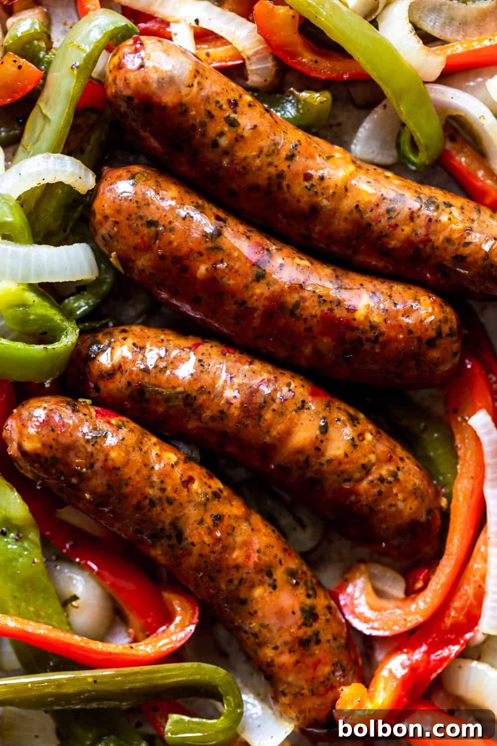 Delicious Sausage, Peppers and Onions Sheet Pan Dinner Cooked sausages with vibrant bell peppers and caramelized onions, ready to serve from a sheet pan.
