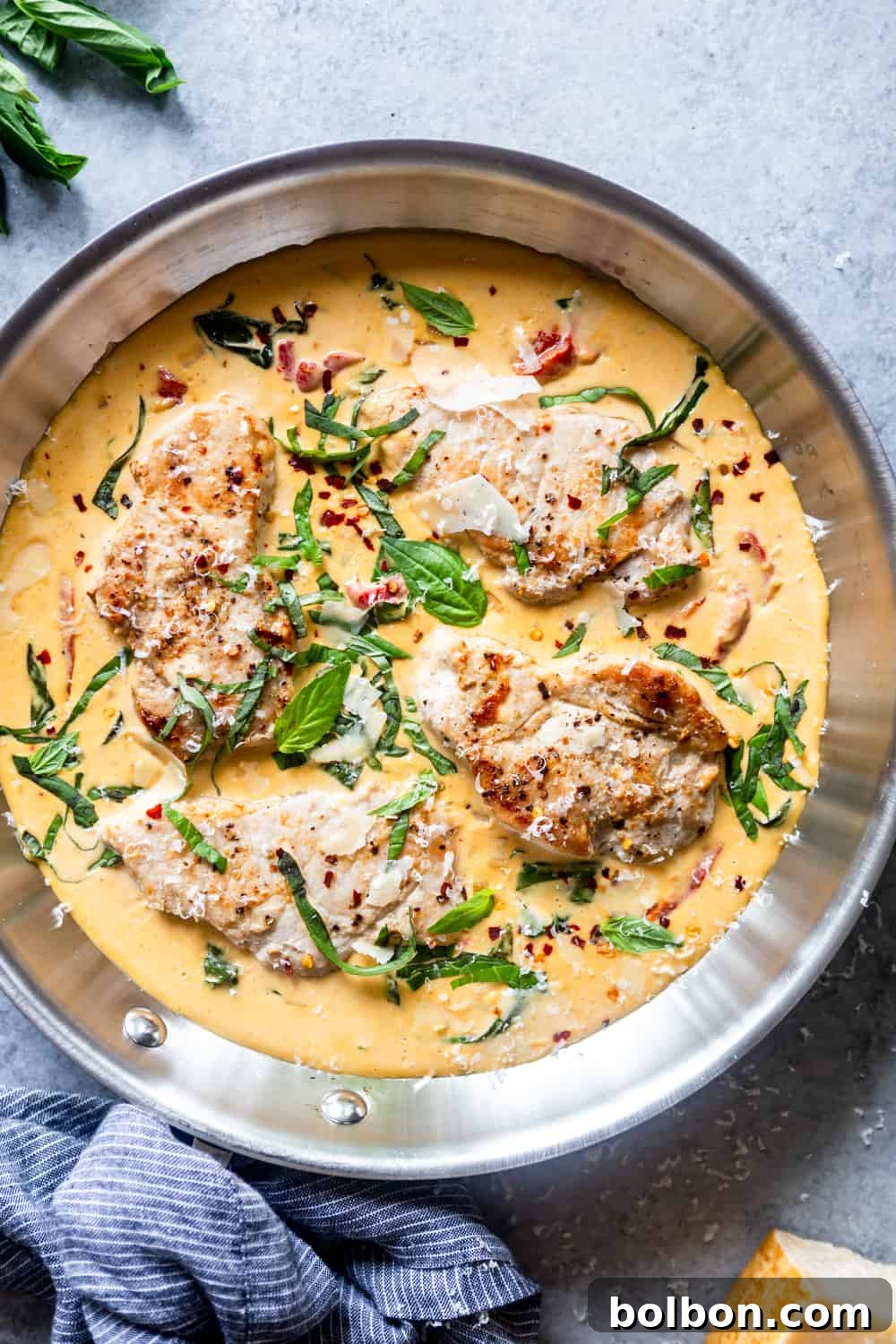 Perfectly cooked, golden-brown pork chops resting in a skillet, ready for the sauce.