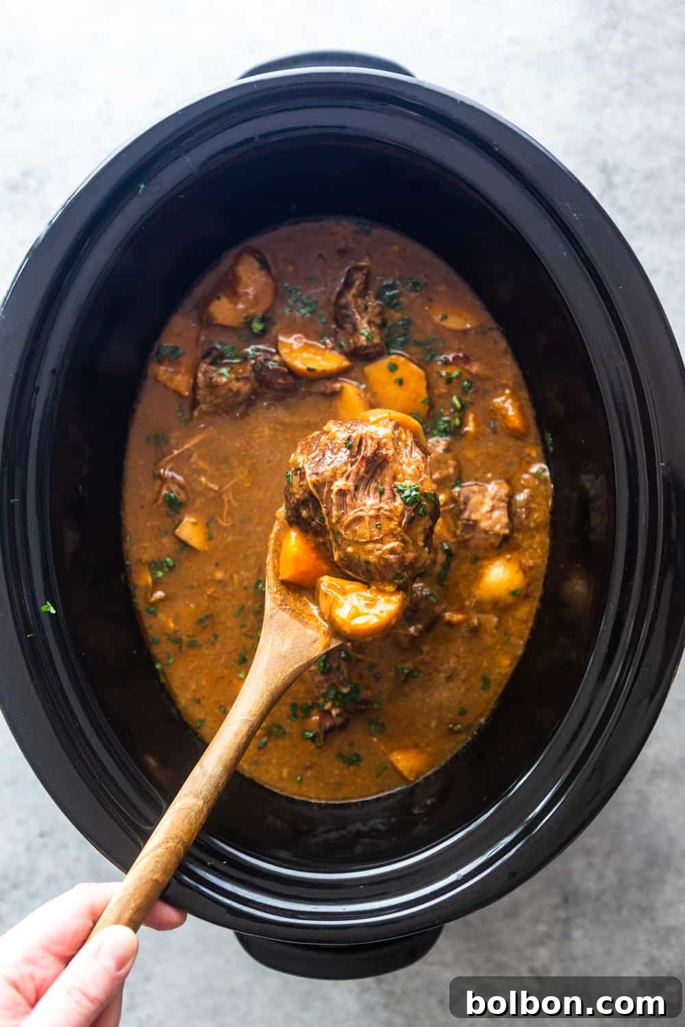 Prepping ingredients for Slow Cooker Irish Beef Stew, showing diced onions and browned beef.