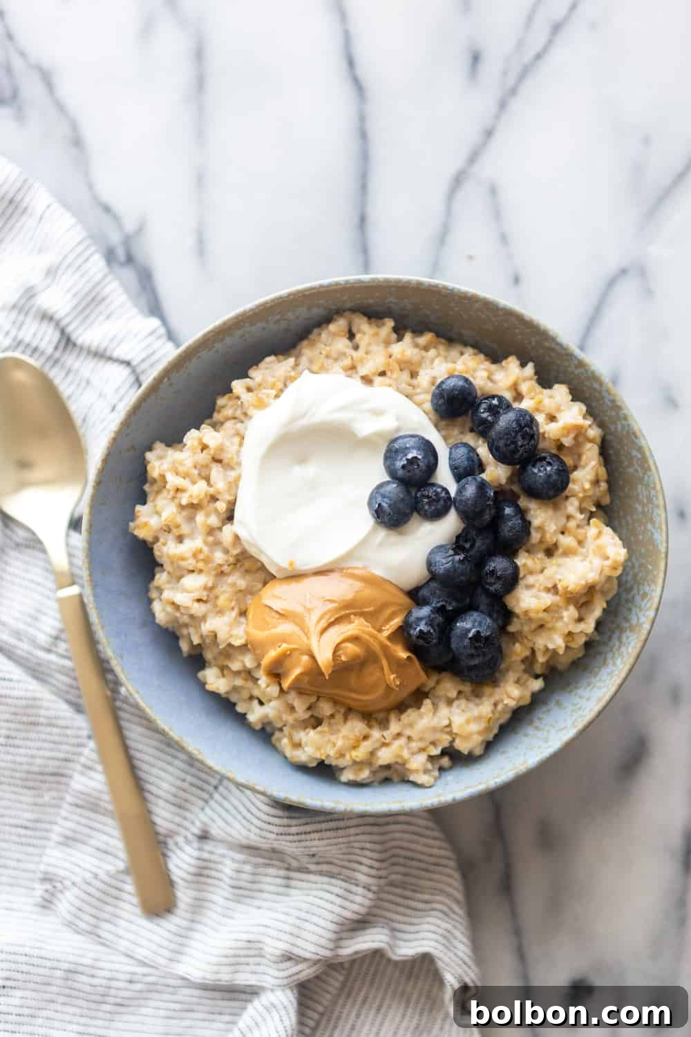 Quick and Creamy Instant Pot Steel Cut Oats 4 Steel cut oatmeal in a blue bowl on a marble slab
