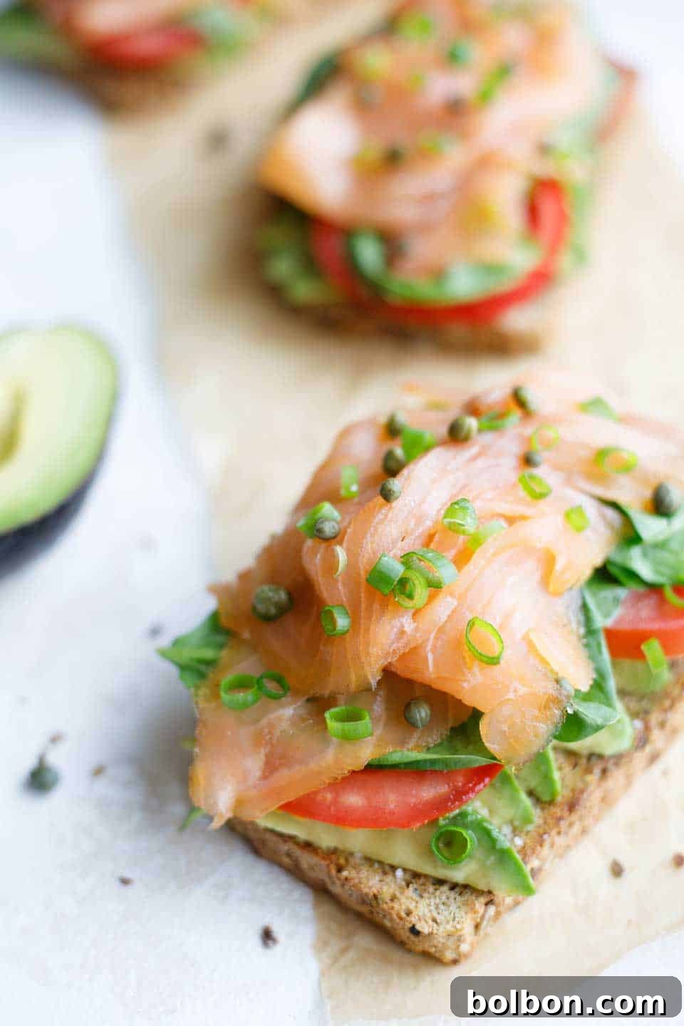 Avocado toast with smoked salmon and herbs on a wooden board