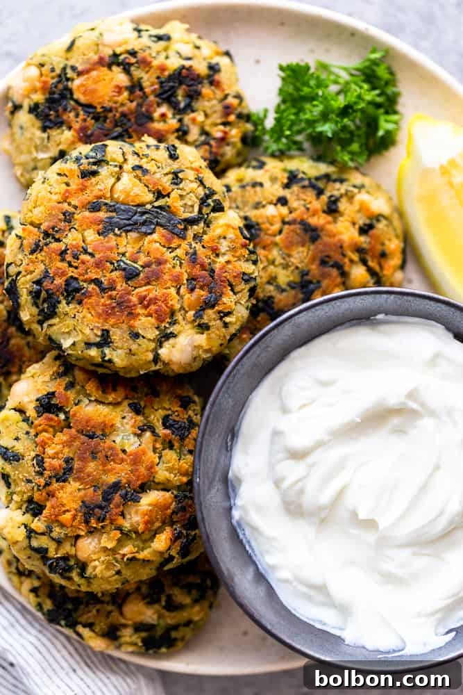 Crispy, golden brown White Bean and Kale Patties cooling on a wire rack, showcasing their perfectly cooked texture and appetizing appearance, ready for serving or meal prepping.