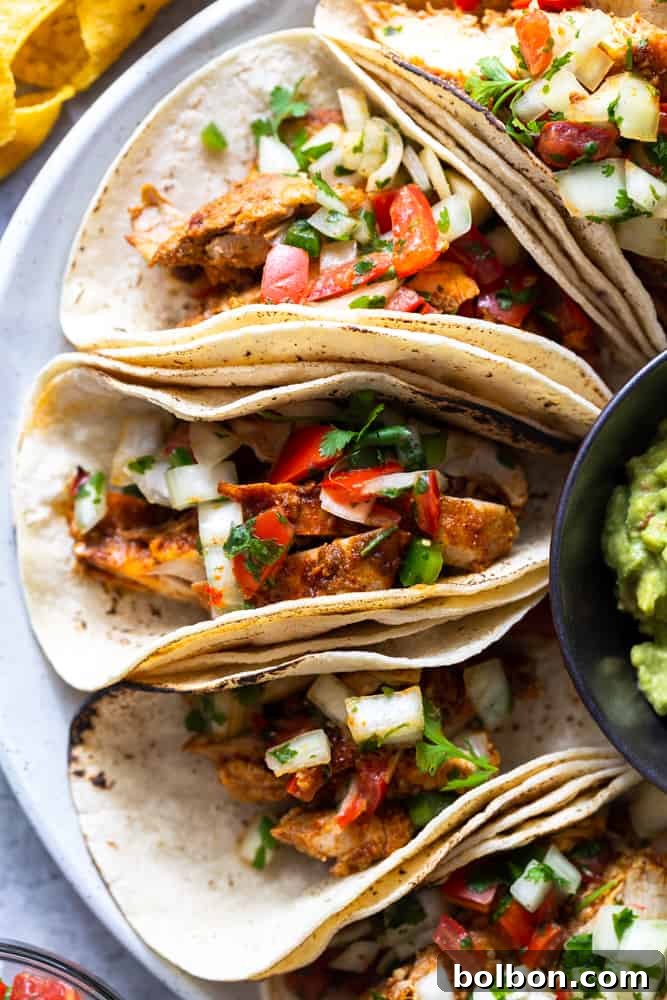 Chili Lime Chicken Tacos, beautifully arranged on a white plate with fresh pico de gallo, ready to be enjoyed as an easy and healthy weeknight dinner. Discover the best chicken taco recipe here.