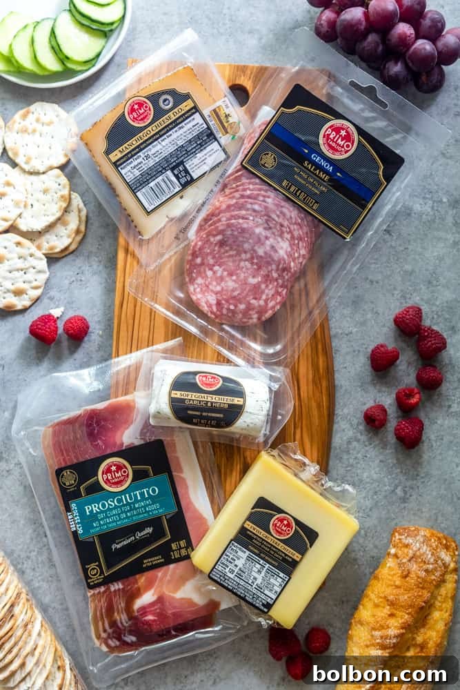 Ingredients for a grazing board, including Primo Taglio Salami, Prosciutto, and cheeses alongside fresh produce