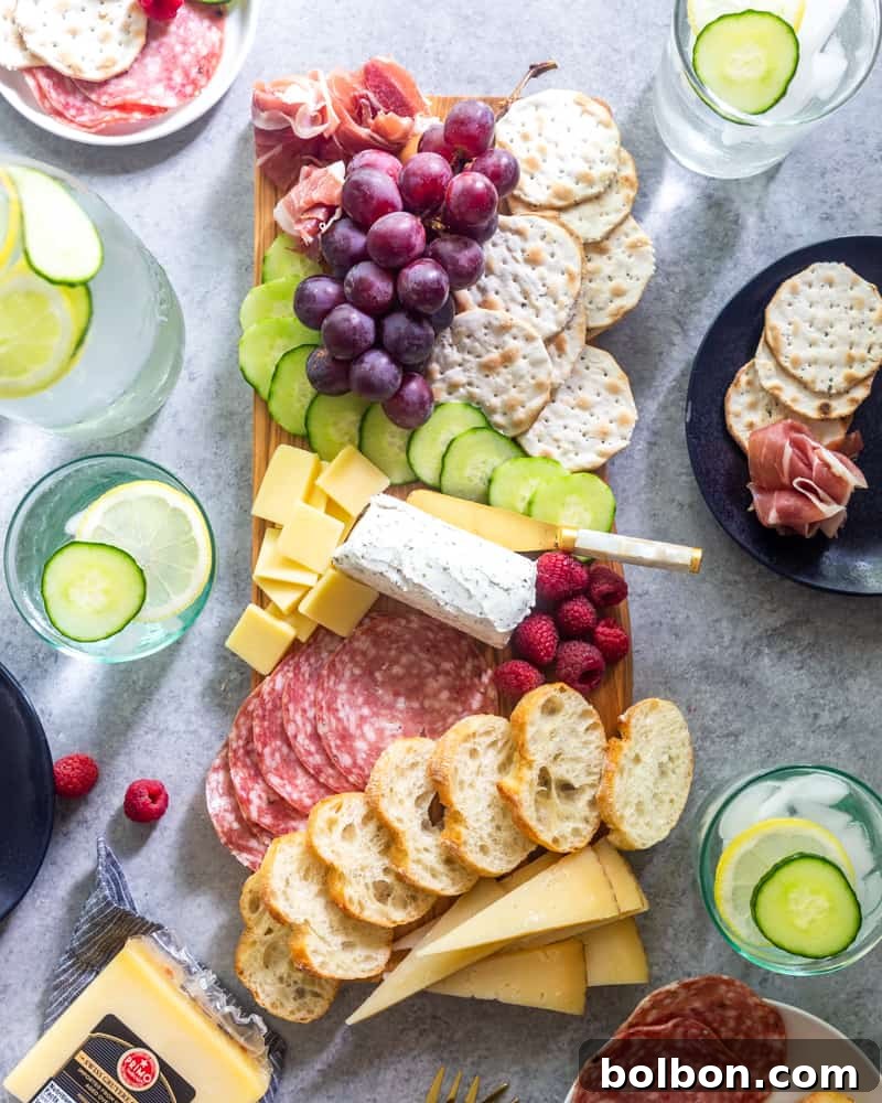 Overhead view of a vibrant charcuterie board with various meats, cheeses, fruits, and bread
