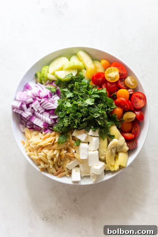 Vibrant Mediterranean Orzo Salad 4 Assortment of fresh ingredients for Mediterranean Orzo Salad, including uncooked orzo pasta, crumbled feta cheese, artichoke hearts, cherry tomatoes, cucumbers, red onion, and fresh herbs like mint and parsley, arranged on a rustic surface