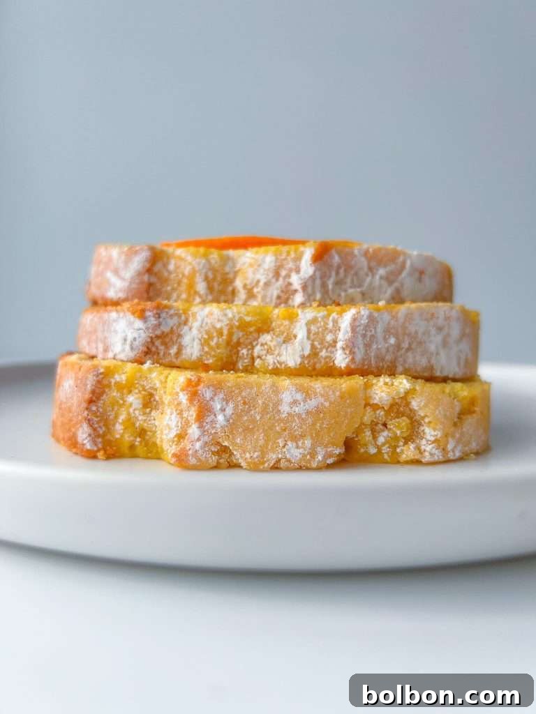 A beautifully baked golden orange blender cake, presented as a single loaf on a simple white background.