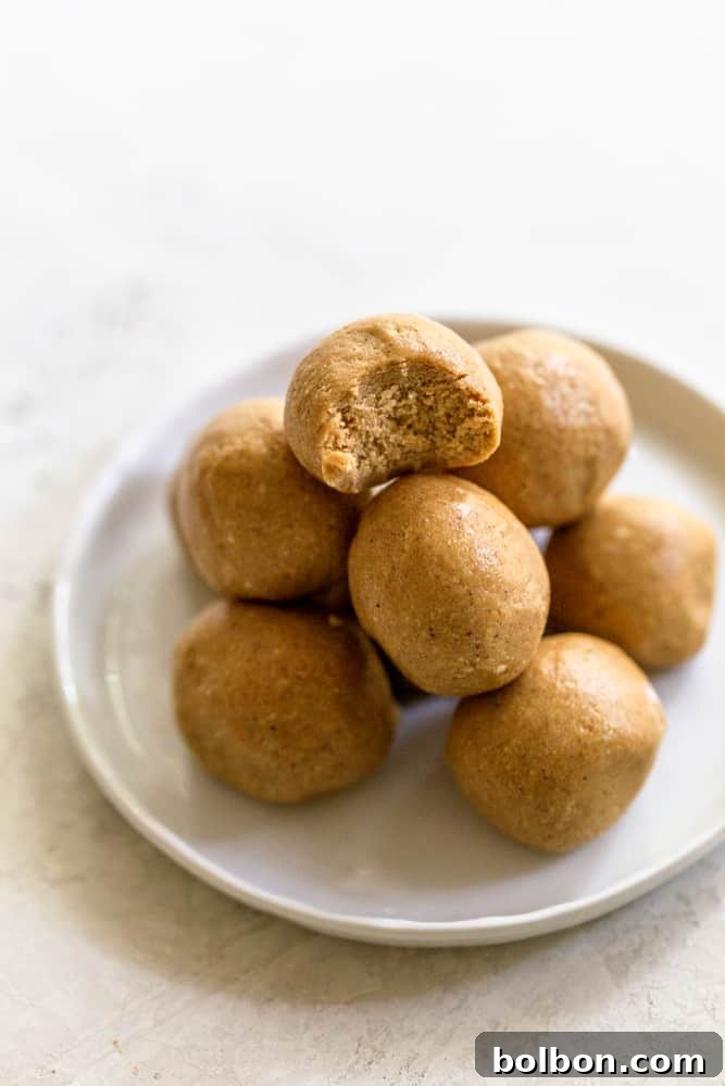 Honey-Sweetened Peanut Butter Power Bites 7 Several peanut butter protein balls arranged neatly on a white plate, showcasing their inviting texture