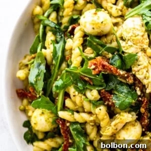A small portion of Chicken Pesto Pasta Salad served in a white bowl