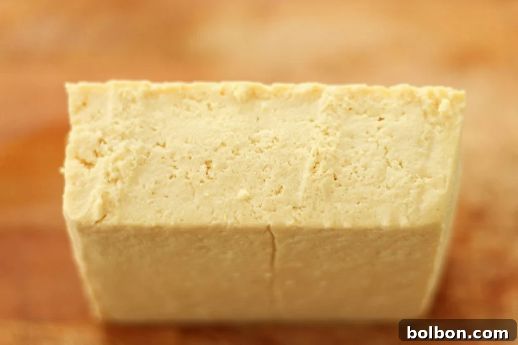 Perfect Tofu Secrets 6 A block of pressed tofu sliced lengthwise through the middle into two thinner slabs.