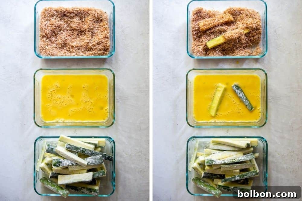 Golden Baked Zucchini Sticks 4 A breading station set up with three bowls: one for flour, one for beaten eggs, and one for the Panko breadcrumb and Parmesan mixture, with zucchini sticks ready for coating.