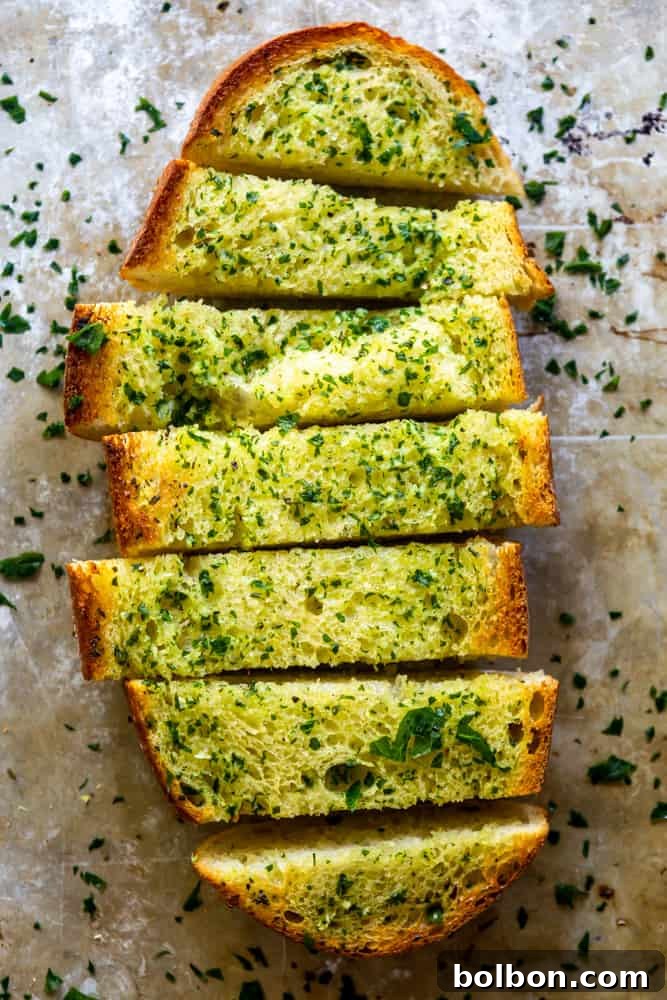 The Ultimate Easy Garlic Bread 2 One half of a loaf of garlic bread sliced, on a baking sheet, ready to be served