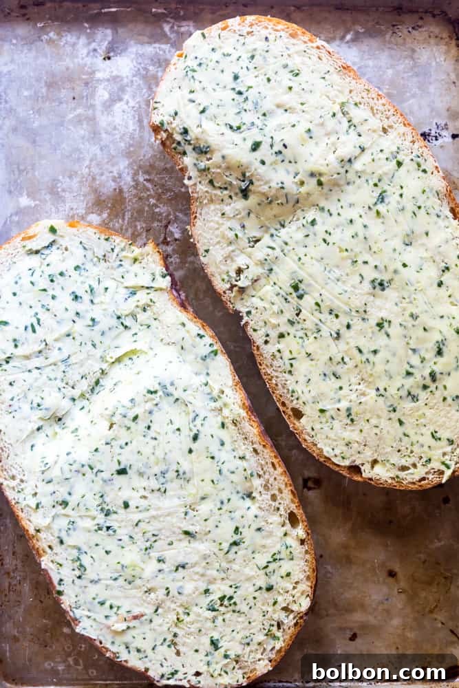 The Ultimate Easy Garlic Bread 4 Loaf of French bread cut in half with garlic butter spread on top, ready for baking