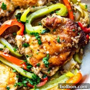 A top-down view of the prepared Chicken Scarpariello, featuring browned chicken, sausage, and colorful peppers in a rich sauce.