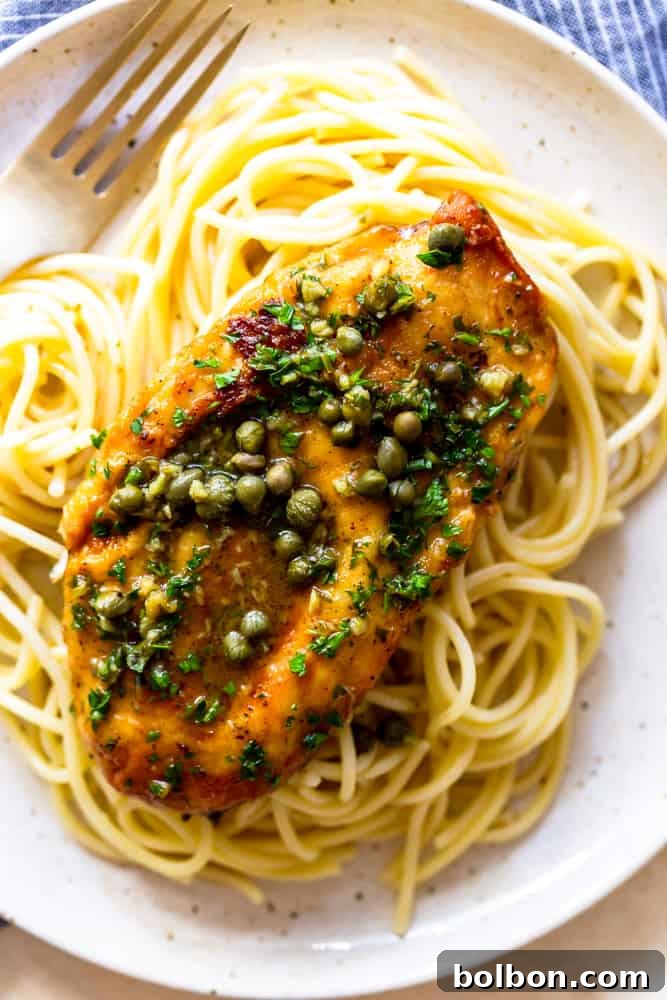 one serving of chicken piccata with capers on a bed of noodles