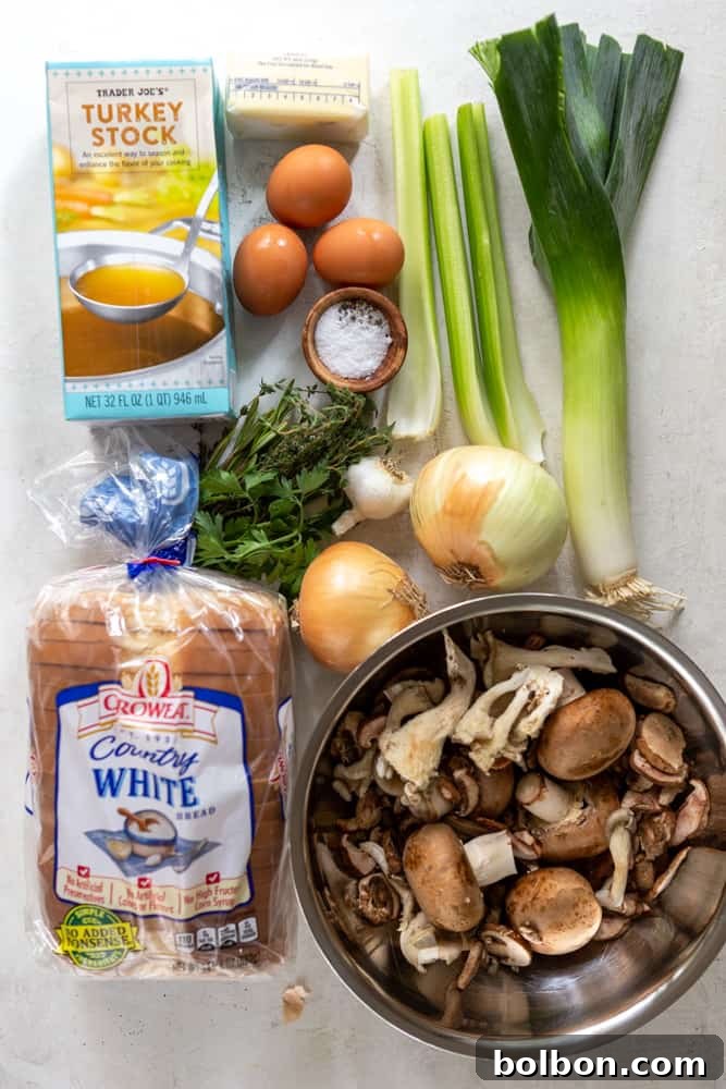 Rustic Mushroom Leek Stuffing 3 Ingredients for homemade mushroom and leek stuffing laid out: turkey stock, eggs, butter, salt, pepper, chopped celery, leek, fresh herbs, garlic, onions, various mushrooms, and cubed bread.