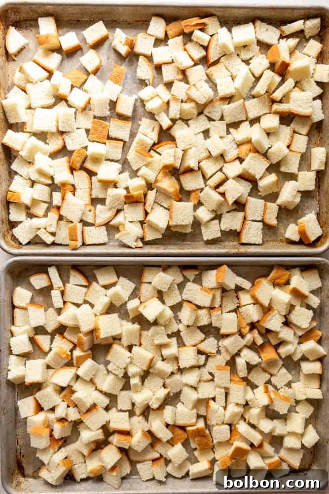 Rustic Mushroom Leek Stuffing 4 Cubed country white sandwich bread spread evenly on two baking sheets, ready for toasting.