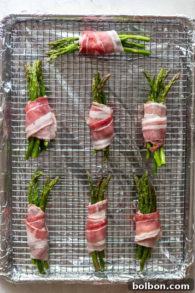 Close-up of fresh green asparagus spears being prepped on a cutting board, ready for wrapping in bacon.