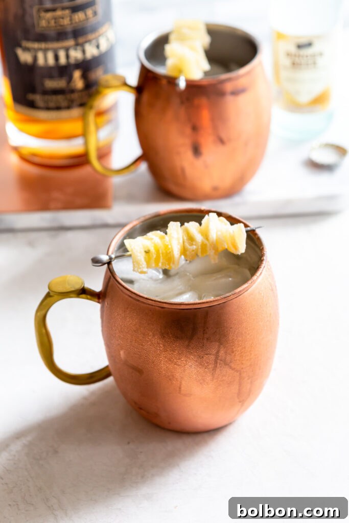 Gingerbread Irish Mule in a copper mug, garnished with candied ginger.