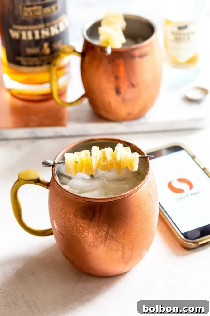 A beautifully presented Gingerbread Irish Mule with a copper mug on a rustic table.