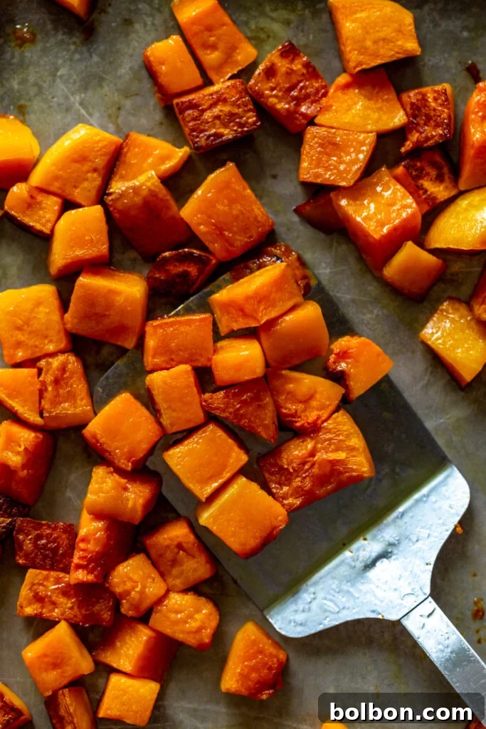 Your Guide to Perfect Butternut Squash Prep 2 Roasted cubes of butternut squash on a baking sheet, golden and tender.
