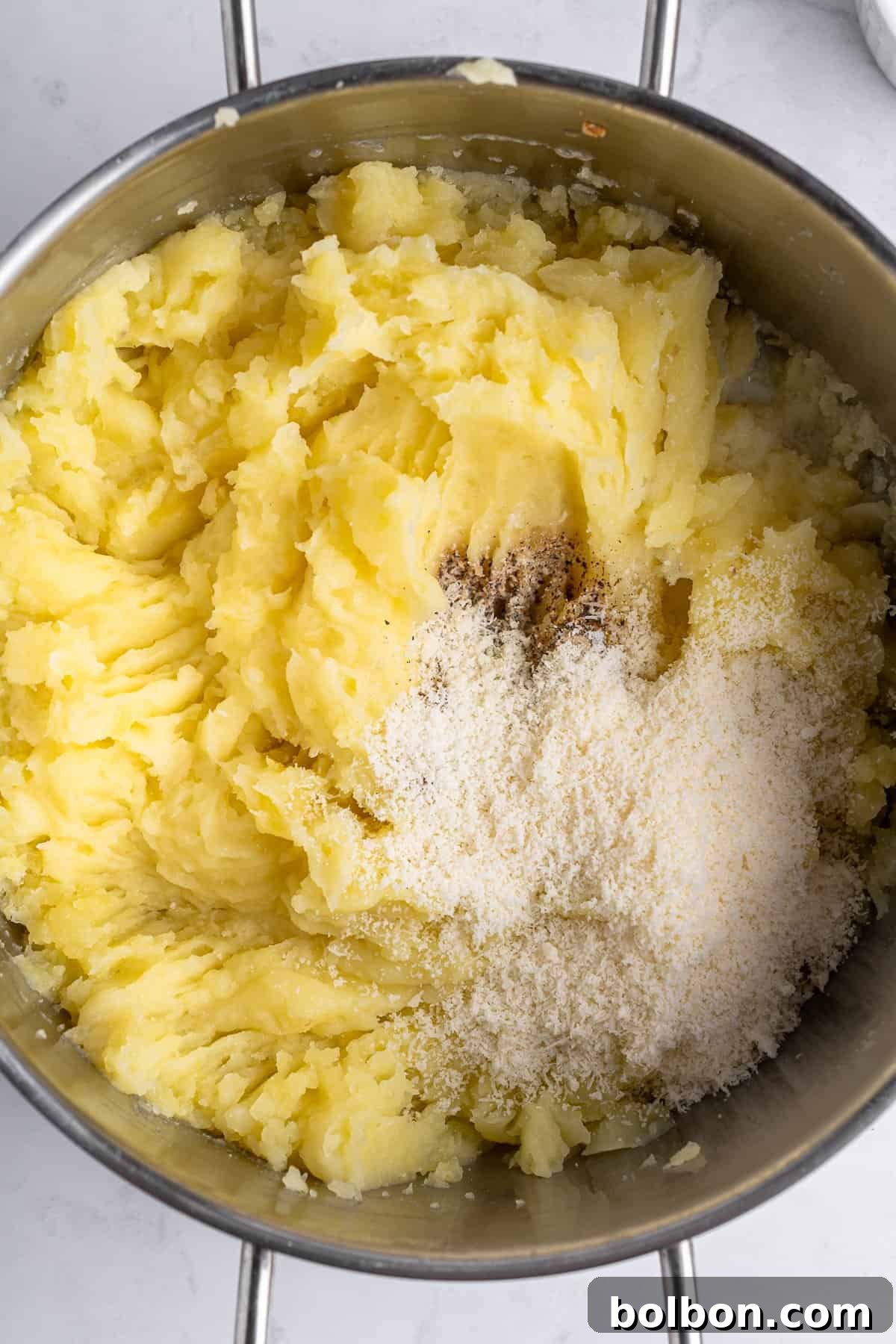 A bowl of mashed potatoes, salt and various spices. 
