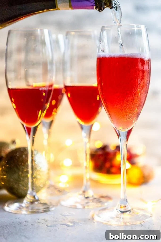 Prosecco pouring into a champagne flute with cranberry juice in it. 