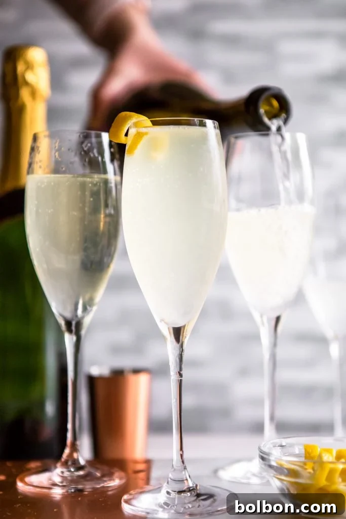 3 French 75 cocktails in champagne flutes, with a bottle of champagne being poured into one. 
