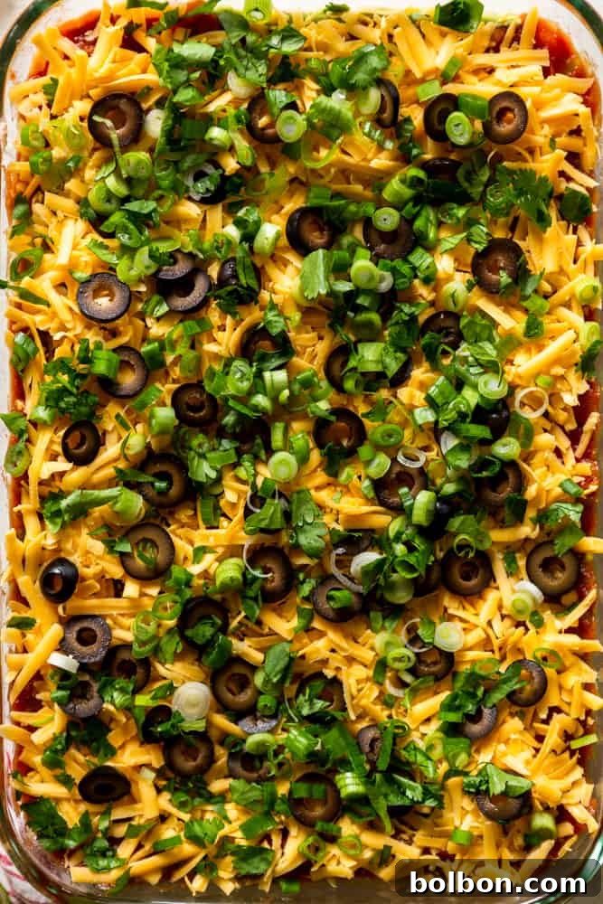 Seven Layer Fiesta Dip 4 Closeup of 7 layer dip with cheese, olives, green onions and cilantro on top.