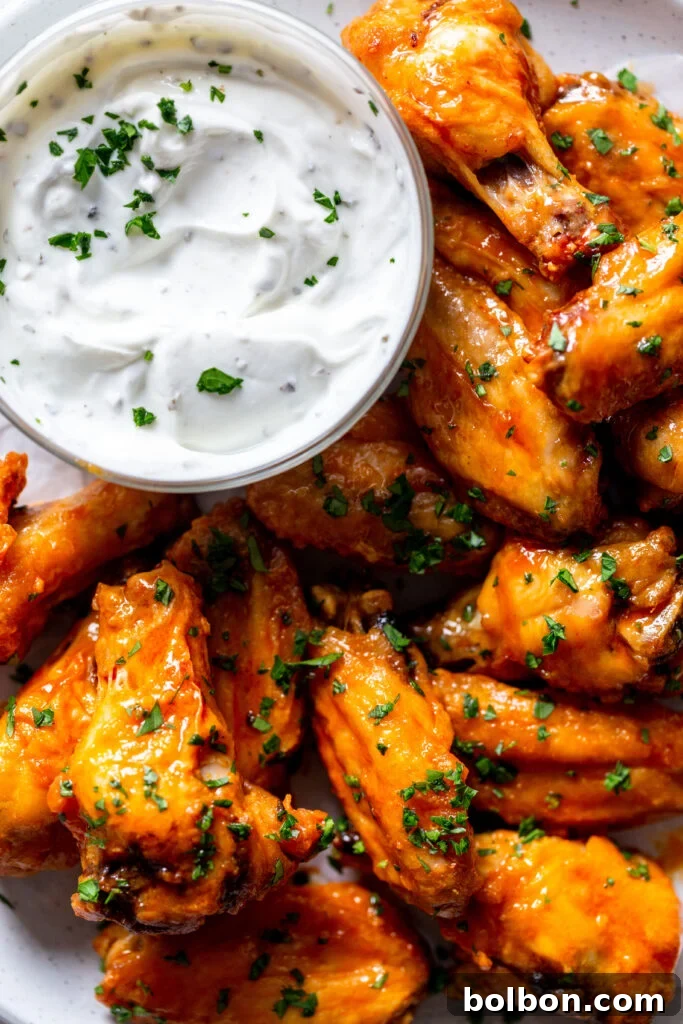 Crunchy Oven-Baked Chicken Wings 2 Baked buffalo wings next to a dish of creamy yogurt dip.