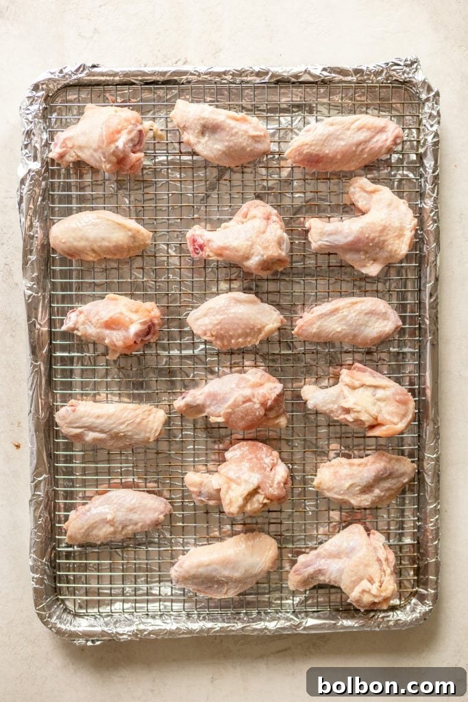 Crunchy Oven-Baked Chicken Wings 5 Freshly coated chicken wings arranged on a baking rack.